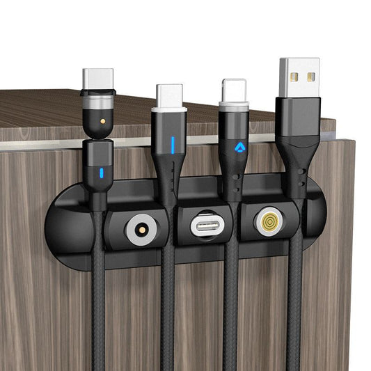 Black desktop charging magnetic data cable organizer on wooden surface